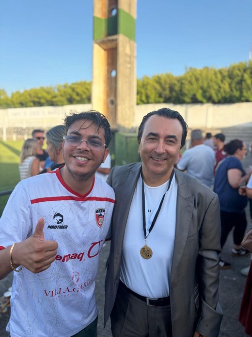 Jai Agarwal in the white Guarda FC shirt beside a medal winner after the match