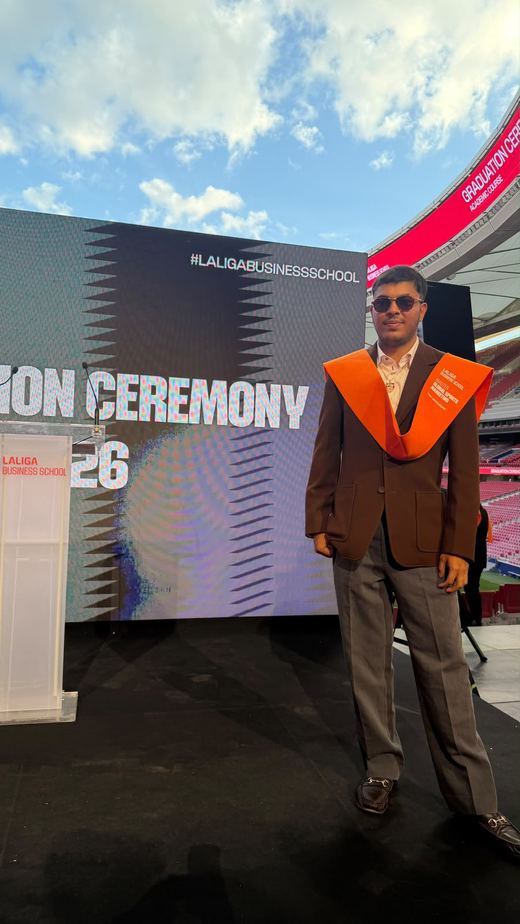 Jai Agarwal in a brown blazer and orange stole in front of the LaLiga Business School graduation ceremony backdrop
