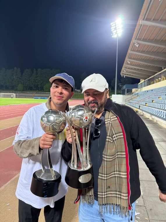 Jai Agarwal and a club director holding both trophies on the track