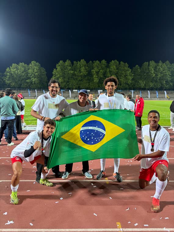 Guarda FC players celebrating on the track with a Brazilian flag